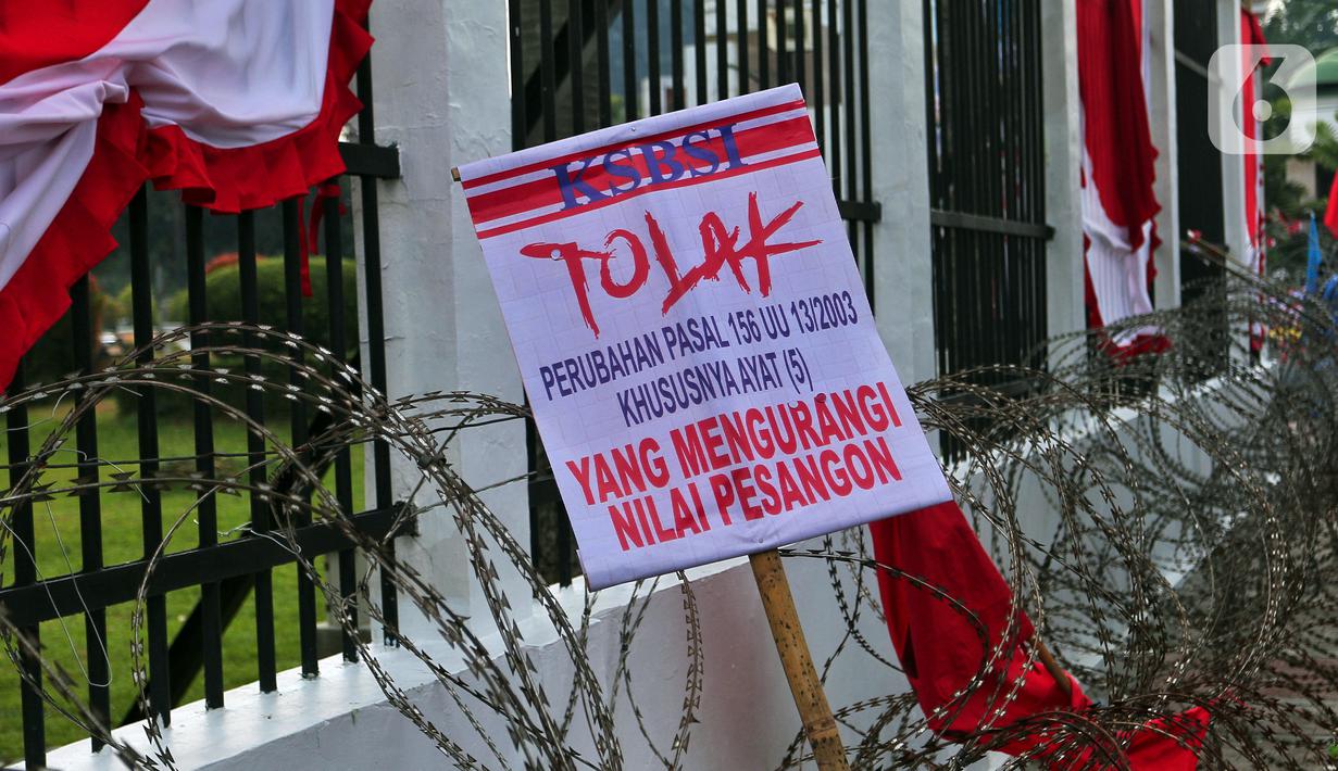 Poster bertuliskan tuntutan terlihat saat sejumlah buruh melakukan unjuk rasa di depan Gedung DPR, Jakarta, Rabu (10/8/2022). Dalam aksi tersebut mereka menuntut agar pemerintah menghapus Omnibus Law. (Liputan6.com/Angga Yuniar)