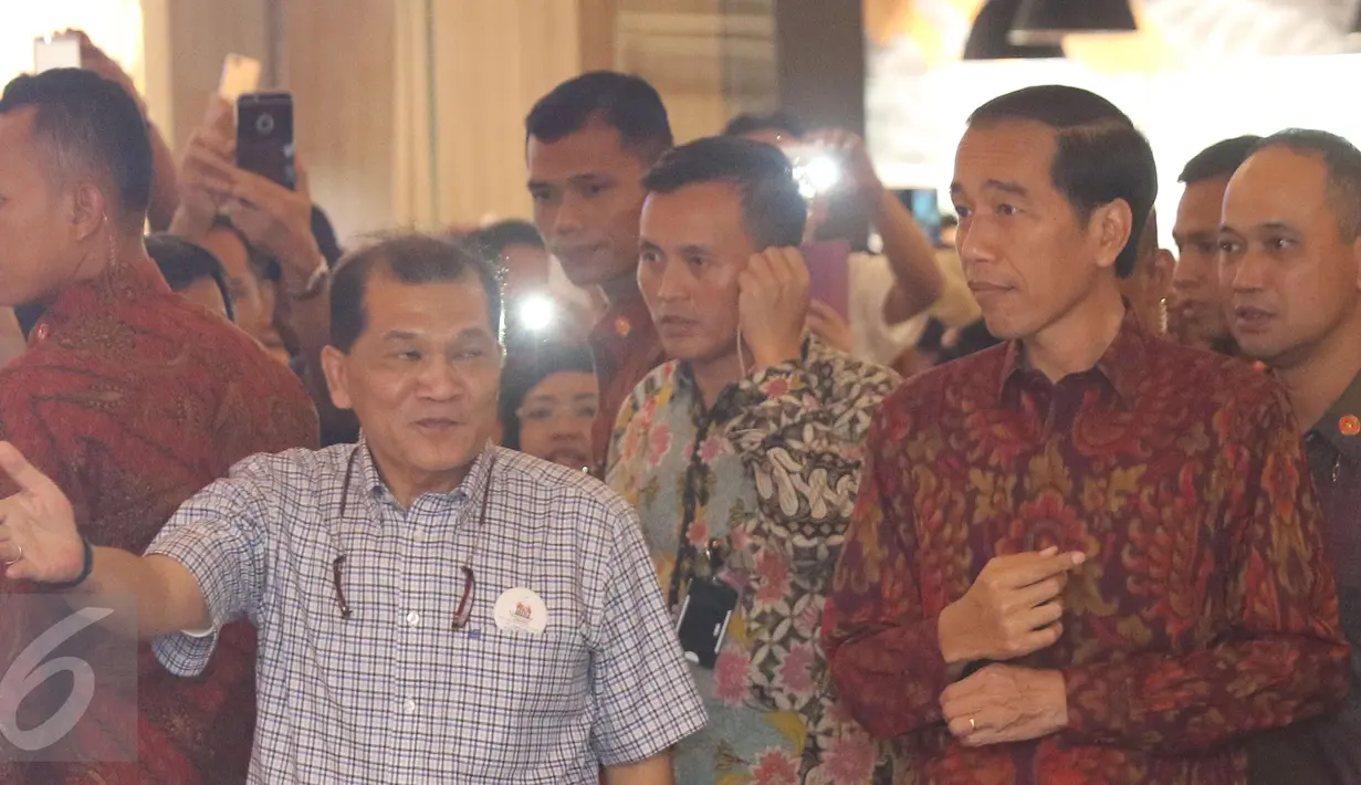 Presiden Joko Widodo (Jokowi) diajak berkeliling melihat pameran foto di Plaza Atrium, Jakarta, Minggu (1/5). Kedatangannya dalam rangka penutupan pameran foto relawan Jokowi bertajuk 'Kaleidoskop Perjuangan Relawan Jokowi'. (Liputan6.com/Herman Zakharia)