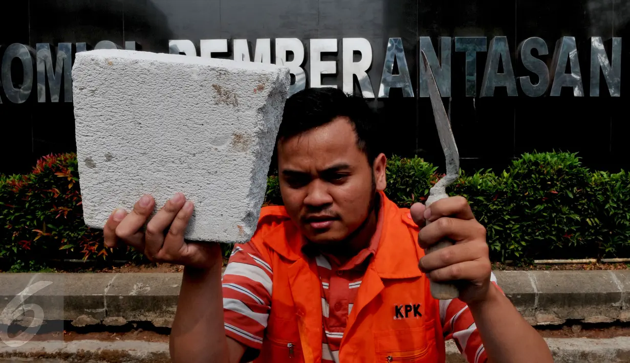 Anggota Koalisi Pemantau Peradilan menunjukkan batu saat aksi peletakkan batu pertama pembangunan museum KPK di halaman KPK, Jakarta, Kamis (8/10/2015). Mereka memprotes DPR yang berencana merevisi UU KPK NO.30 th 2002 (Liputan6.com/Andrian M Tunay)