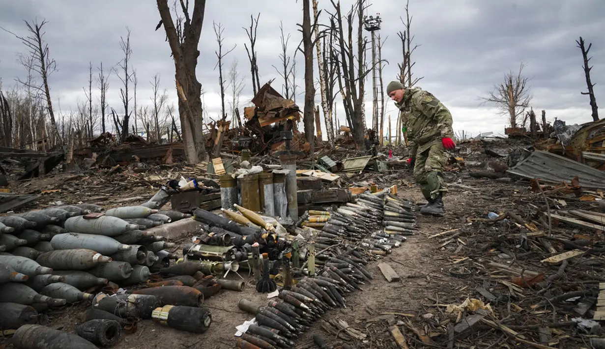 Seorang pencari ranjau dari Kementerian Dalam Negeri Ukraina mengumpulkan selongsong peluru, granat, dan perangkat lain yang belum meledak di Hostomel, dekat Kiev, Ukraina, 18 April 2022. (AP Photo/Efrem Lukatsky)
