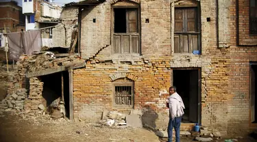 Seorang pria berdiri di luar rumahnya yang rusak akibat gempa tahun lalu di Nepal, Jum'at (29/1/2016). Gempa bumi pada bulan April dan Mei 2015 silam menewaskan hampir 9.000 orang dalam bencana alam terburuk Nepal. (Reuters/Navesh Chitrakar)