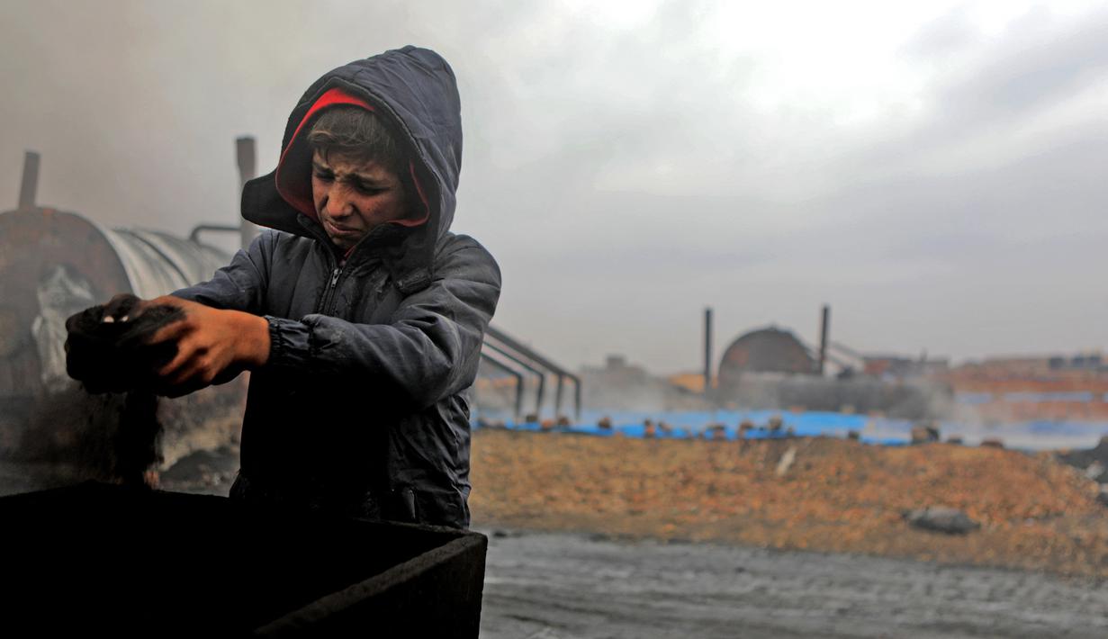 Amer al-Shayban (12) dari Suriah bekerja di kilang minyak darurat dekat Kota al-Bab yang dikuasai Turki, Suriah, 20 November 2021. Sebanyak 1,6 juta anak Suriah juga berisiko putus sekolah. (Bakr ALKASEM/AFP)