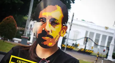 Jaringan Solidaritas Korban untuk Keadilan dan penggiat HAM mengenakan topeng Munir di depan Istana Negara, (4/9/14). (Liputan6.com/Faizal Fanani)