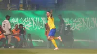 Pemain Al-Nassr, Cristiano Ronaldo merayakan gol pertama timnya ke gawang Al-Ahli pada laga Liga Arab Saudi yang berlangsung di King Saud University Stadium, Riyadh, Arab Saudi, Sabtu (23/09/2023) dini hari WIB. Gol ini dinilai cukup kontroversial karena sisi gawang Al-Ahli yang dijaga oleh Edouard Mendy terlihat tertutup asap yang cukup tebal hasil nyala suar dari para pendukung Al-Nassr. (AFP/Fayez Nureldine)