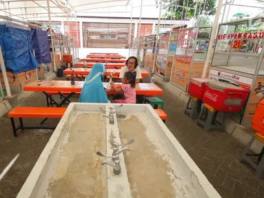 Pedagang berbincang sambil menunggu pembeli di Lokasi Binaan (Lokbin) Kota Tua, Jakarta, Selasa (9/1). Keberadaan parkir liar di kawasan Kota Tua sebagai penyebab enggannya pengunjung berbelanja di lokasi binaan tersebut. (Liputan6.com/Angga Yuniar)