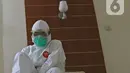 dr Rahmadi Iwan Guntoro, Sp.P memakai sepatu boots di Rumah Sakit Haji, Jakarta, Kamis (9/4/2020). Gugus Tugas Percepatan Penanganan COVID-19 telah mengeluarkan rekomendasi standar APD berdasarkan tiga tingkatan perlindungan. (Liputan6.com/Herman Zakharia)