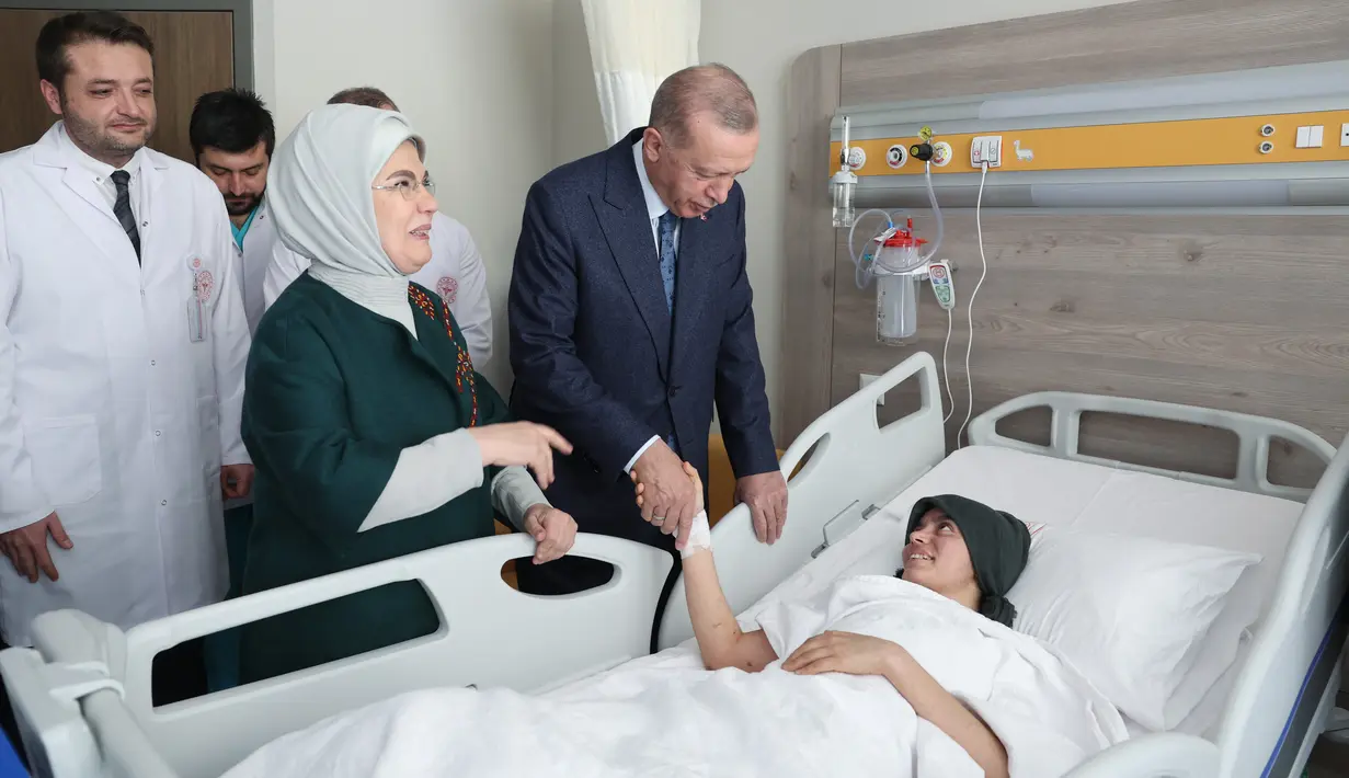Presiden Turki Recep Tayyip Erdogan dan istrinya Emine Erdogan mengunjungi anak korban gempa yang menerima perawatan di Fakultas Kedokteran Universitas Ankara setelah dipindahkan dari daerah yang dilanda gempa di Turki, 22 Februari 2023 .  Erdogan mengatakan total 70 ribu rumah akan dibangun di desa-desa terdampak gempa yang berpusat di Kahramanmaras, guna menghidupkan kembali daerah tersebut.  (Press Office of the Presidency of Turkey / AFP)