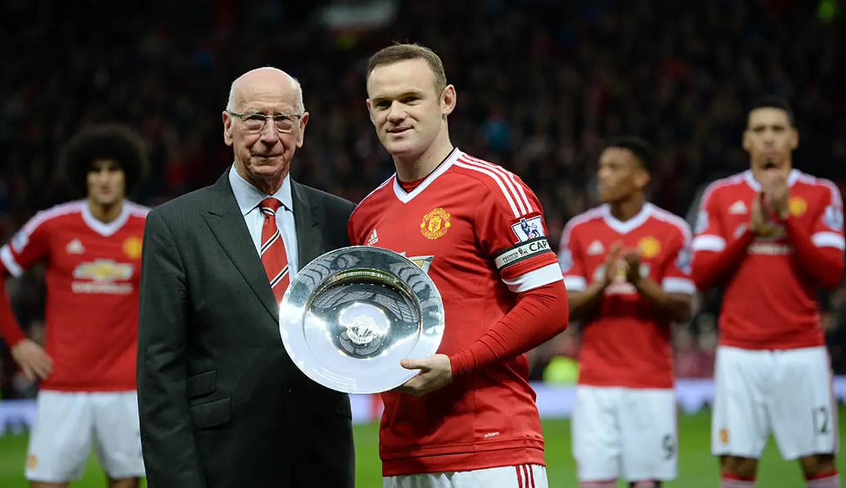 Legenda MU, Sir Bobby Charlton, memberikan penghargaan kepada Wayne Rooney sebelum menjalankan laga ke-500 bersama Setan Merah. (AFP/Oli Scarff)