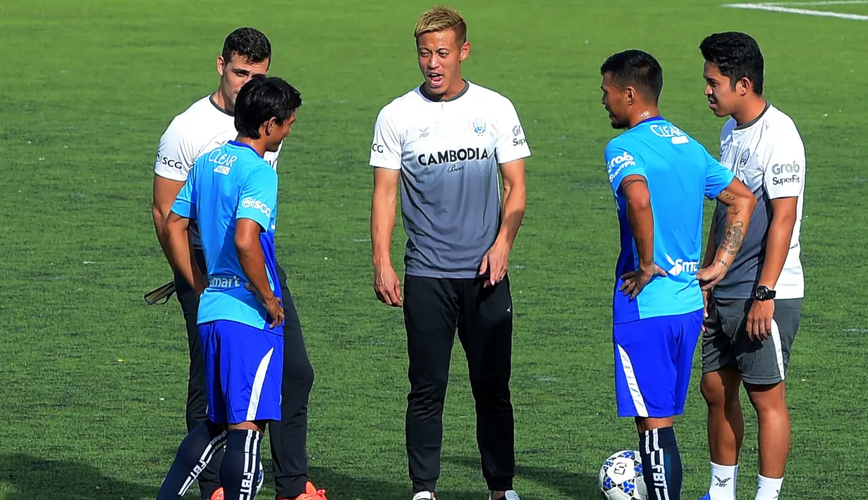 Eks gelandang AC Milan, Keisuke Honda berbincang dengan pemain timnas Kamboja berlatih di Stadion Olimpiade Nasional di Phnom Penh, (4/9). Honda juga diberi jabatan sebagai GM Timnas Kamboja. (AFP Photo/Tang Chhin Sothy)