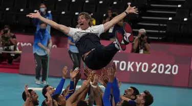 Pemain Prancis melemparkan pelatih kepala Laurent Tillie ke udara saat mereka merayakan kemenangan atas Russian Olympic Committee pada pertandingan final bola voli putra Olimpiade Tokyo 2020 di Tokyo, Jepang, Sabtu (7/8/2021). Prancis mengalahkan ROC 3-2. (AP Photo/Frank Augstein)