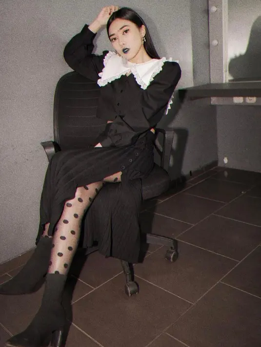 Dalam pemotretan untuk album Il Sogno, Isyana tampil chic bergaya gothic mengenakan dress warna hitam dengan detail kerah renda. (Instagram/isyanasarasvati).