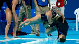 Anggota tim polo air putri AS mendorong pelatihnya, Adam Krikorian, ke kolam setelah meraih emas dengan mengalahkan Belanda di Kejuaraan Dunia Akuatik 2015 di Kazan, Rusia. (7/8/2015). (Reuters/Michael Dalder)