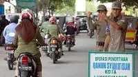 Dua personil Polisi Wailayatul Hisbah (WH) memperhatikan pengguna jalan yang memasuki kawasan razia celana ketat di Lhokseumawe, Aceh.(Antara)