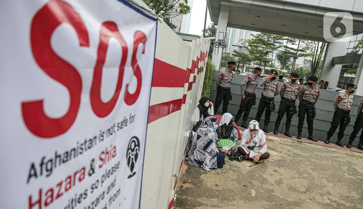 Polisi berjaga saat pengungsi Afghanistan melakukan unjuk rasa di depan Kantor UNHCR, Jakarta, Kamis (31/3/2022). Pengungsi Afghanistan memprotes ketidakpedulian UNHCR dan meminta pejabat terkait meninjau kembali kasus migrasi serta pemukiman kembali mereka. (Liputan6.com/Faizal Fanani)