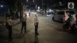 Polisi berjaga pada malam takbiran di Jalan KH Mas Mansyur, Jakarta, Sabtu (23/5/2020). Polisi dikerahkan menjaga Jalan KH Mas Mansyur untuk mengantisipasi adanya takbir keliling di kawasan tersebut. (Liputan6.com/Faiza Fanani)