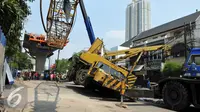 Pekerja mengevakuasi crane yang jatuh di Jalan Kyai Maja, Jakarta Selatan, Kamis (15/10/2015). Akibat kecelakaan ini, ‎lalu lintas di lokasi terganggu. Ruas Jalan Kyai Maja ditutup karena dilakukan pemindahan alat berat. (Liputan6.com/Helmi Afandi)