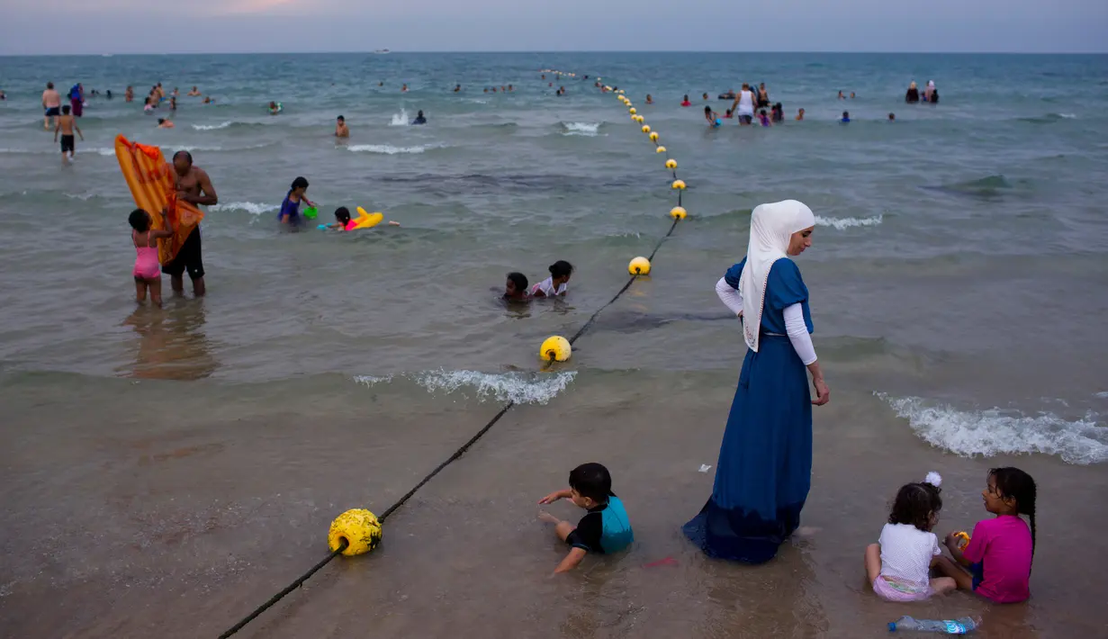 Pemandangan saat warga Palestina menghabiskan libur Idul Fitri di pantai Tel Aviv, Israel, Sabtu (16/6). Pemerintah Israel mengizinkan warga Palestina untuk berwisata di sepanjang garis pantai Mediterania selama Idul Fitri. (AP Photo/Oded Balilty)