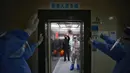 Petugas medis melambaikan tangan kepada pasien yang terjangkit virus corona COVID-19 di Rumah Sakit Palang Merah di Wuhan, Provinsi Hubei, China, 16 Maret 2020. Kasus baru pasien terinfeksi virus corona COVID-19 di negara yang menjadi pusat penyebaran pandemi ini mulai menurun.  (Photo by STR/AFP)