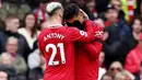 Pemain Manchester United, Antony, berusaha menenangkan Casemiro yang menerima kartu merah saat pertandingan melawan Southampton di Stadion Old Trafford, Minggu (12/3/2023). (AFP/Darren Staples)