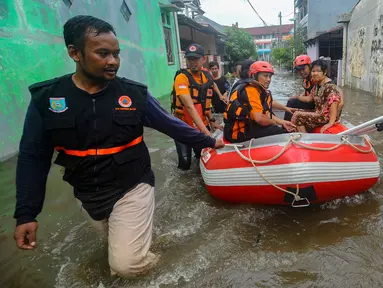 Tim SAR dari Badan Penanggulangan Bencana Daerah (BPBD) Tangerang Selatan mengevakuasi warga lanjut usia (lansia) yang sakit saat banjir di Perumahan Taman Mangu, Tangerang Selatan, Banten, Selasa (12/11/2024). (merdeka.com/Arie Basuki)