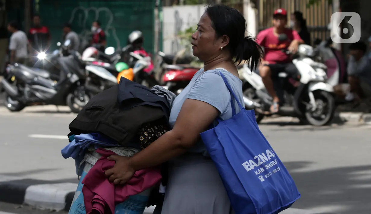 Warga mengamankan barang berharga saat api membakar pemukiman di kawasan Jalan Kebayoran Lama, Jakarta, Minggu (30/10/2022). Sebanyak 20 unit mobil damkar dikerahkan. Total sekitar 100 personel yang turun ke lokasi memadamkan api. (Liputan6.com/Helmi Fithriansyah)