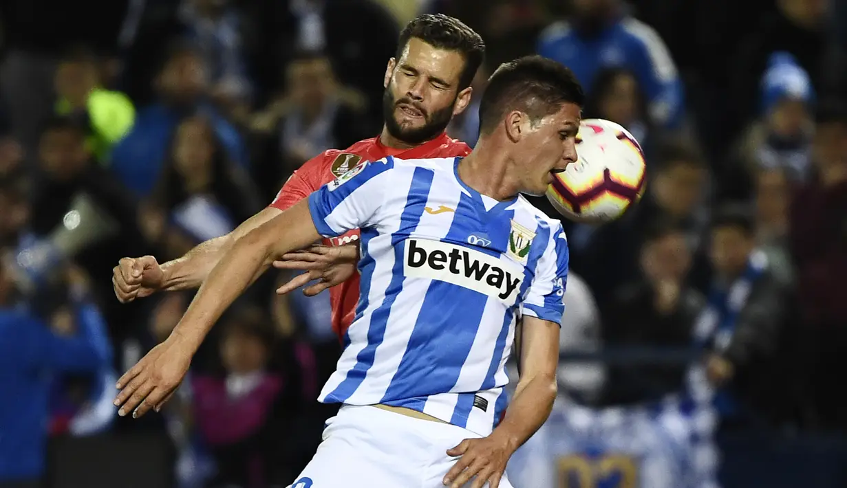 Bek Real Madrid, Nacho Fernandez, duel udara dengan striker Leganes, Guido Carrillo, pada laga La Liga di Stadion Municipal Butarque, Senin (15/4). Kedua tim bermain imbang 1-1. (AFP/Pierre Philippe Marcou)