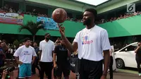 Pemain NBA dari Boston Celtics, Jaylen Brown menunjukkan kemampuannya memutar bola basket dengan satu jari saat memberi coaching clinics untuk siswa-siswi di SMAN 82 Jakarta, Kamis (26/7). (Liputan6.com/Arya Manggala)