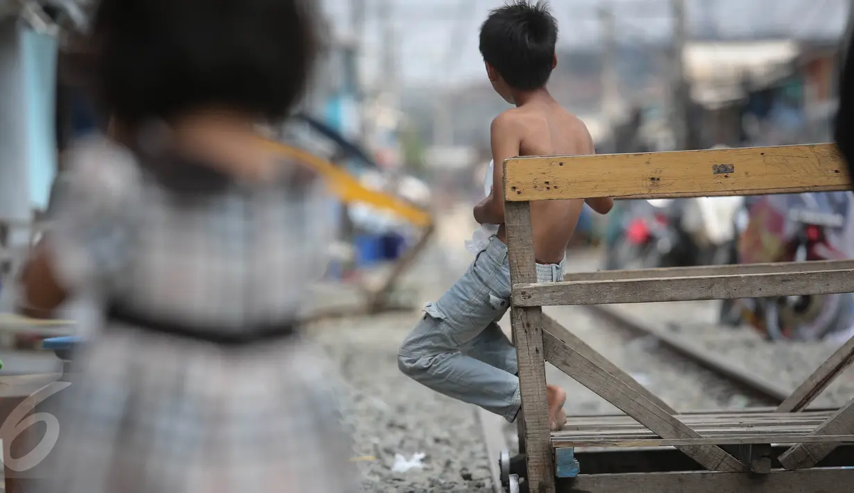 Seorang anak duduk di atas ojek lori di kawasan Kampung Bandan, Jakarta, Selasa (28/7/2015). Keberadaan lori ini dimanfaatkan sebagai sarana transportasi alternatif bagi warga yang bermukim di kawasan pinggir rel tersebut. (Liputan6.com/Faizal Fanani)