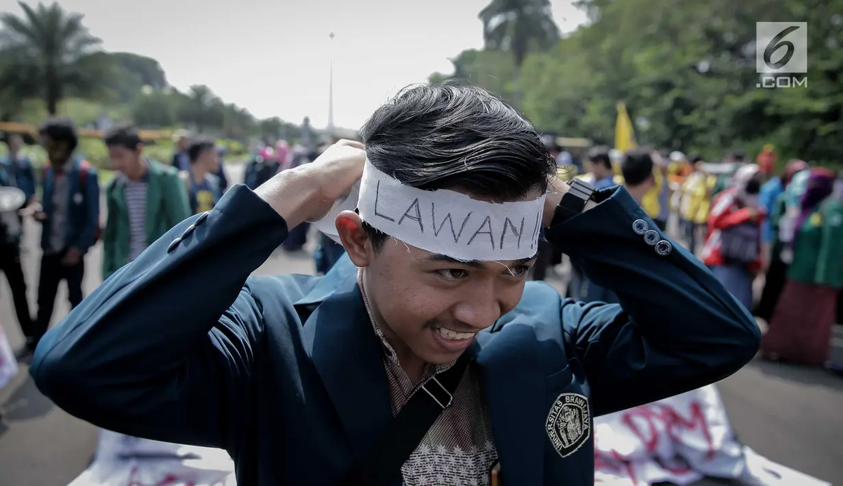 Seorang mahasiswa memakai ikat kepala saat aksi longmarch menuju Istana Merdeka, Jakarta, Senin (22/5). BEM SI menuntut kembalikan subsidi listrik 900VA dan BBM. (Liputan6.com/Faizal Fanani)