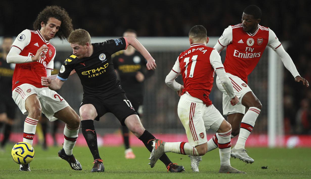 Gelandang Manchester City, Kevin De Bruyne (kedua kiri) berusaha melewati tiga pemain Arsenal pada pertandingan lanjutan Liga Inggris di di Stadion Emirates, London (15/12/2019). City menang telak atas Arsenal 3-0. (AP Photo/Ian Walton)
