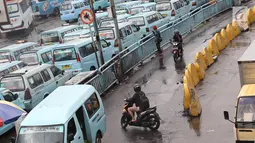 Pengendara sepeda motor melintasi jalur angkutan umum di Terminal Kampung Melayu, Jakarta, Rabu (6/2). Sejumlah pengendara nekat menerobos masuk terminal untuk memotong jalur guna memersingkat waktu tempuh. (Liputan6.com/Immanuel Antonius)