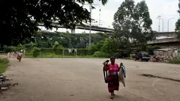 Warga membawa jemurannya di kawasanan pemukiman kumuh di kolong Tol Pluit, Jakarta, Kamis (14/12). Kebanyakan, mereka yang tinggal di tempat tersebut adalah buruh serabutan yang mengadu nasib di Jakarta. (Liputan6.com/JohanTallo)