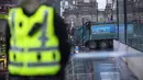 Seorang polisi berdiri di dekat sebuh truk sampah yang menabrak pejalan kaki di pusat Kota Glasgow, Skotlandia, Selasa (23/12/2014). (REUTERS/Stringer)