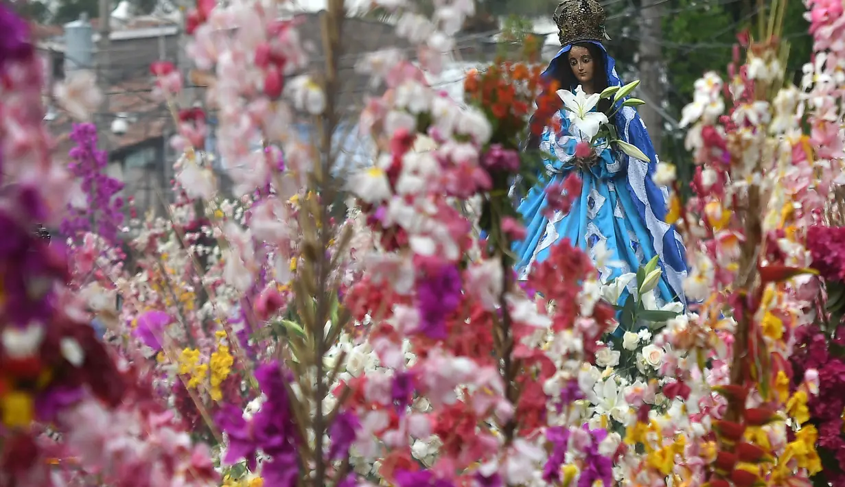 Sebuah patung Bunda Maria diarak saat festival tahunan Panchimalco Flower and Palm Festival di Panchimalco, San Salvador (6/5). Acara ini untuk menghormati santo pelindung mereka yang dikenal "Fiesta de las Flores y Palmas". (AFP/Marvin Recinos)
