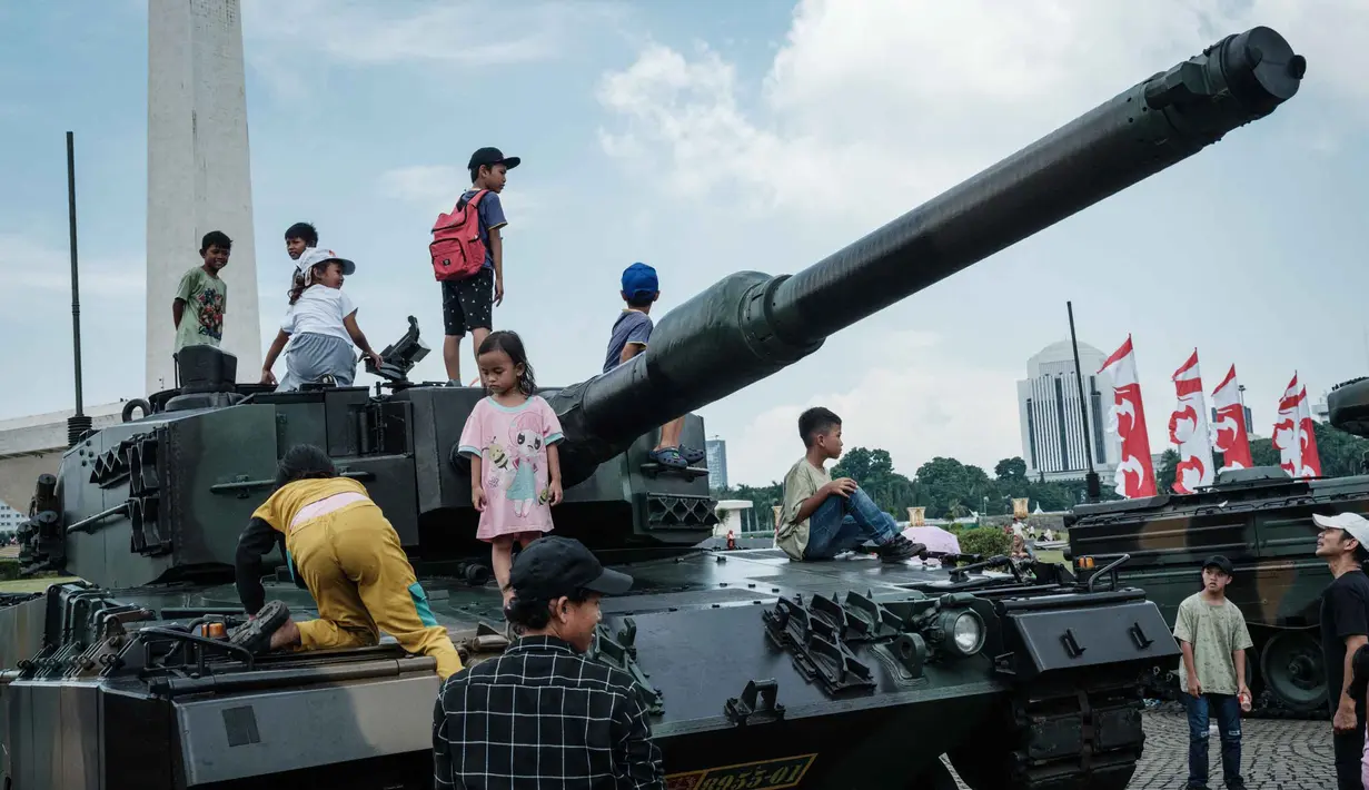 Warga yang berkunjung ke Monumen Nasional (Monas) di Jakarta terlihat antusias menyaksikan sekaligus menaiki sejumlah alutsista TNI yang dipamerkan. (YASUYOSHI CHIBA/AFP)