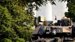 Seorang wanita berjalan ketika kendaraan pengangkut lapis baja Bradley terparkir di Lincoln Memorial, Washington, Rabu (3/7/2019). Presiden Donald Trump berencana memamerkan Tank-tank tempur sebagai bagian dari perayaan Hari Kemerdekaan AS yang dikenal sebagai Fourth of July. (AP/ Andrew Harnik)