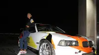 Seorang model berpose di samping mobil yang dipakai ABM Motorsport (istimewa)