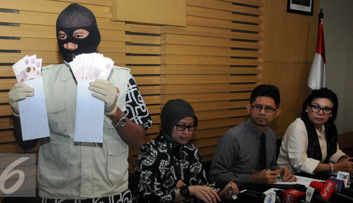 Petugas memperlihatkan barang bukti dalam OTT yang dilakukan KPK terhadap Panitera Pengganti Pengadilan Negeri Jakarta Pusat dengan mengamankan barang bukti uang sebesar 28.000 dolar Singapura, Jakarta, Jumat (1/7). (Liputan6.com/Helmi Afandi)