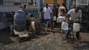 Warga Palestina mengumpulkan air minum di pabrik desalinasi di Deir al-Balah, Jalur Gaza Tengah, Rabu 13 Agustus 2025. (AP Photo/Abdel Kareem Hana)