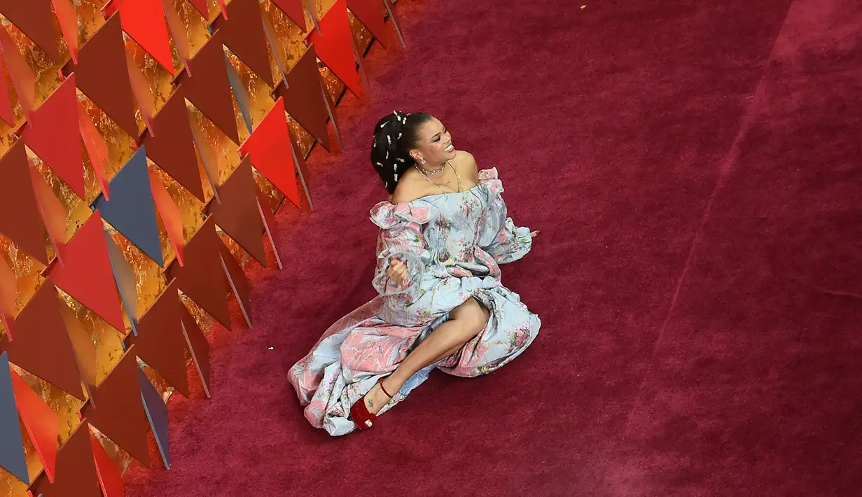 Penyanyi Andra Day berpose untuk fotografer sambil rebahan di atas karpet merah penghargaan Piala Oscars 2018 di Dolby Theatre, Los Angeles, Minggu (4/3). Pose Andra Day yang lain dari pada lain tersebut menyita perhatian. (Robyn Beck / AFP)