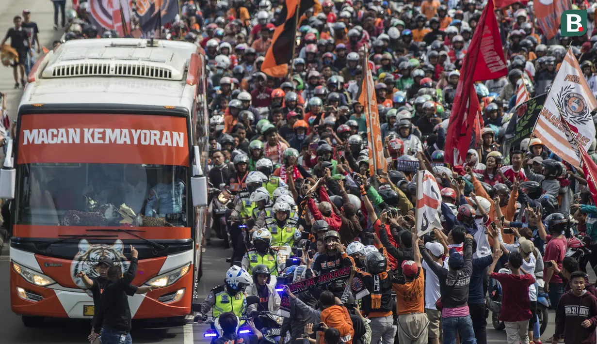 Suporter Persija Jakarta, The Jakmania, konvoi merayakan gelar Piala Presiden dengan melintasi Senayan hingga Monas, Jakarta, Minggu (18/2/2018). Persija meraih juara setelah mengalahkan Bali United. (Bola.com/Vitalis Yogi Trisna)