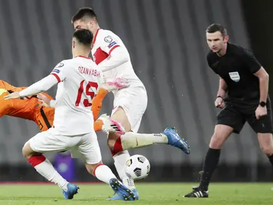Gelandang Belanda, Georginio Wijnaldum, terjatuh saat berebut bola dengan bek Turki, Ozan kabak, pada laga kualifikasi Piala Dunia 2022 di Stadion Olimpiade Ataturk, Kamis (25/3/2021). Turki menang dengan skor 4-2. (Tolga Bozoglu/Pool Photo via AP)