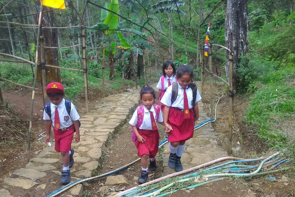 Anak-anak Dusun Pesawahan, Gununglurah, Cilongok, Banyumas, melintas berkilometer di tengnah hutan untuk bersekolah di desa tetangga. (Foto: Liputan6.com/Muhamad Ridlo)