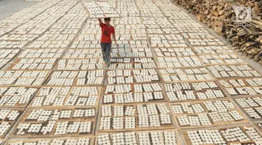 Pekerja mengeringkan kerupuk kaleng di industri UMKM Nineung di Pamulang, Tangsel, Banten, Jumat (21/6/2019). Kenaikan harga tepung tapioka yang mencapai lebih dari seratus persen semenjak beberapa bulan terakhir menyebabkan produsen kerupuk mengurangi kualitas kerupuk. (merdeka.com/Arie Basuki)