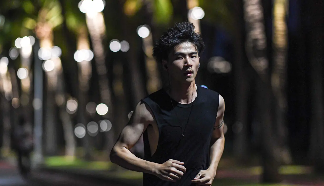 Seorang pria berlari di Taman Wanlu di Haikou, Provinsi Hainan, China selatan, pada 21 Mei 2020. Berlari di malam hari menjadi olahraga yang populer di kalangan warga Haikou. (Xinhua/Pu Xiaoxu)