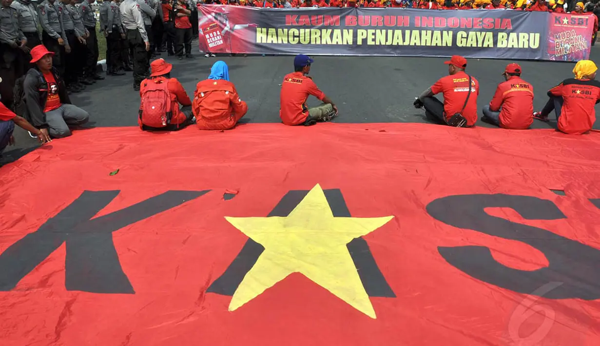 Para buruh membentangkan spanduk bertuliskan "Kaum Buruh Indonesia Hancurkan Penjajahan Gaya Baru" di depan Istana Merdeka, Jakarta, (15/9/14). (Liputan6.com/Miftahul Hayat)
