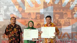 Ketua Bawaslu, Abhan (kanan) bersama Ketua PPUA Panca, Ariani Soekanwo menunjukkan nota kesepahaman atau MoU pada perayaan HUT 1 Dasawarsa Bawaslu di Jakarta, Senin (9/4). (Liputan6.com/Helmi Fithriansyah)