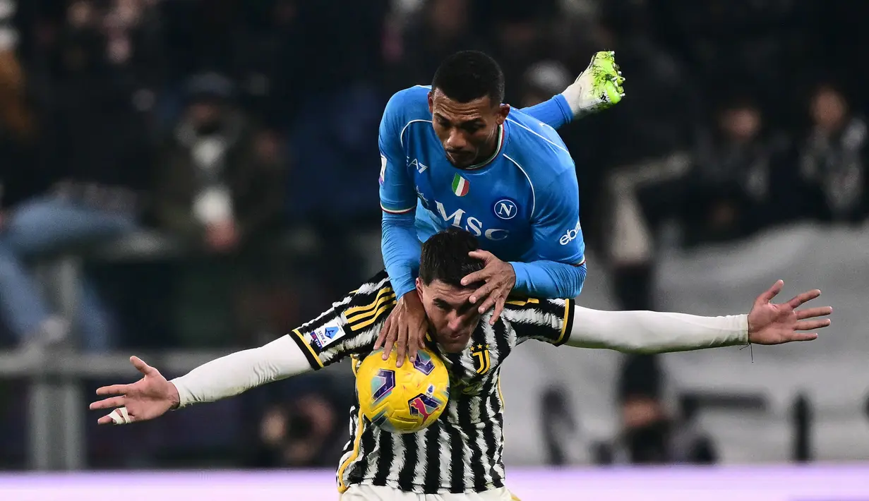 Pemain Juventus, Dusan Vlahovic (bawah), berebut bola dengan pemain Napoli, Juan Jesus, dalam pertandingan pekan ke-15 Liga Italia 2023/2024 yang berlangsung di Allianz Stadium, Sabtu (9/12/2023) dini hari WIB. (AFP/Marco Bertorello)