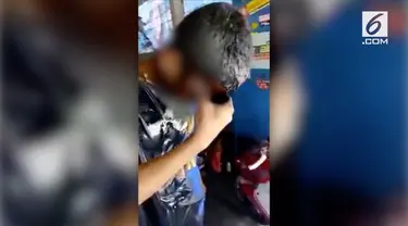 Rekaman video seorang anak yatim piatu diminta mandi oli karena ketahuan mencuri onderdil bekas di sebuah bengkel.