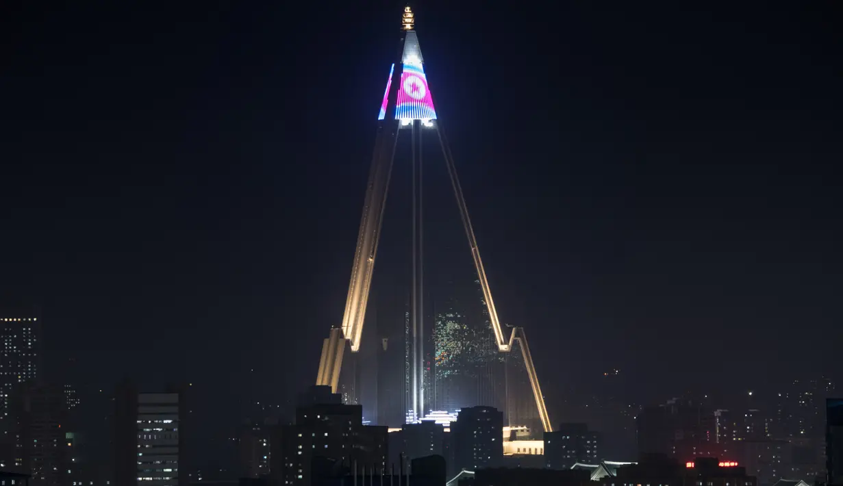Pertunjukan cahaya menampilkan bendera Korea Utara di atas hotel Ryugyong di kota Pyongyang, Korea Utara (9/4). (AFP Photo/Ed Jones)